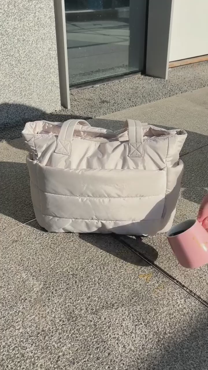 „Beżowa torba Softi na zewnątrz, test wodoodporności, woda wylewana na materiał.”