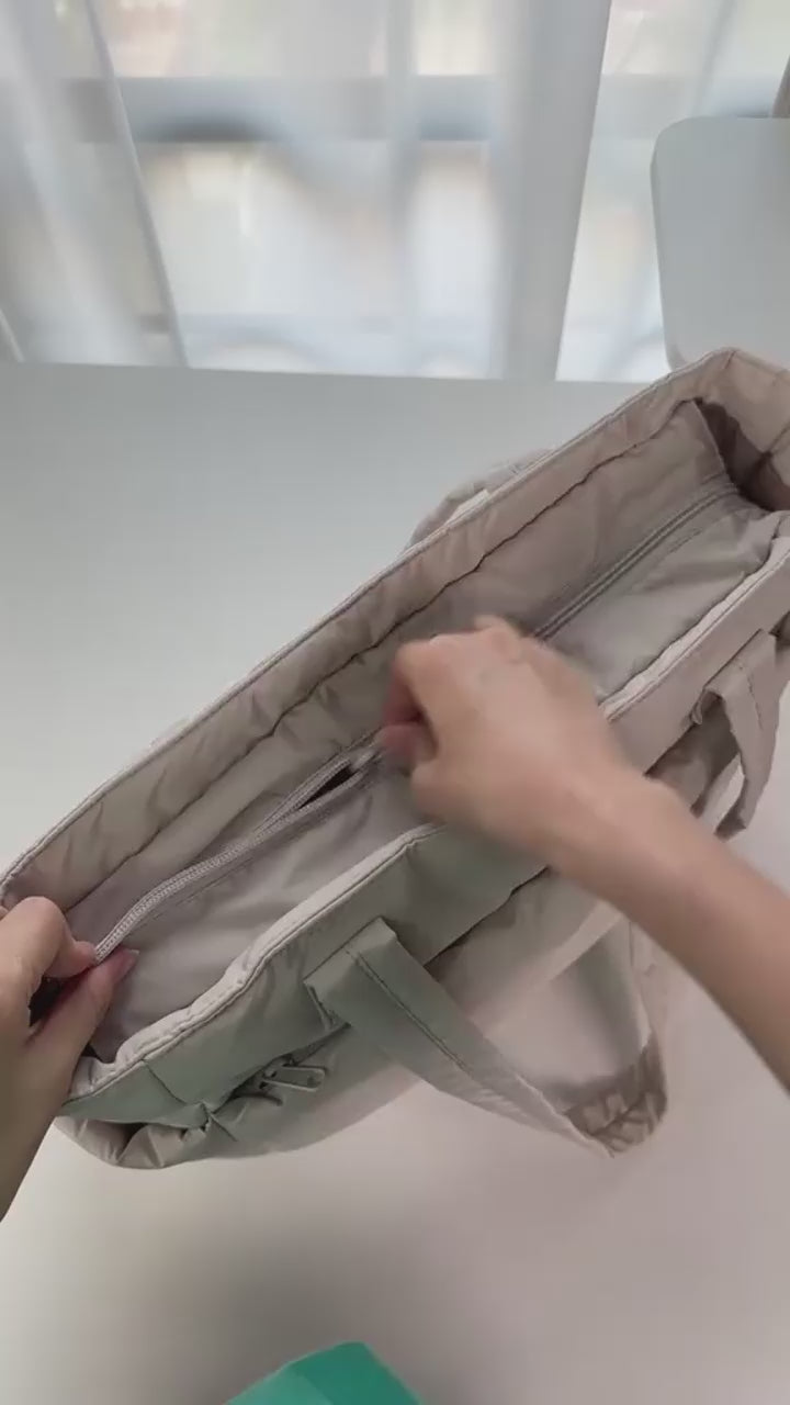 „Kremowa torba Softi wypełniona laptopem, przekąskami i akcesoriami, prezentacja organizacji wnętrza.”