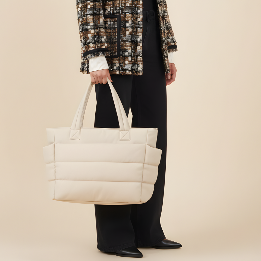 „Beżowa torba Softi z pikowanym wykończeniem, niesiona przez modelkę w ruchu na jasnym tle.”