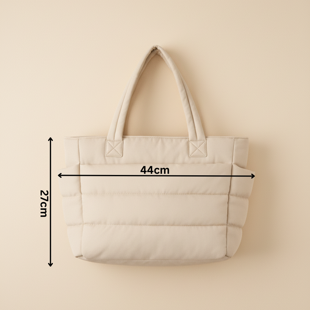 Beżowa torba Softi z pikowanym wykończeniem, przedstawiona na jasnym tle, z zaznaczonymi wymiarami 44 cm na 27 cm, ukazująca kompaktowy i elegancki design.